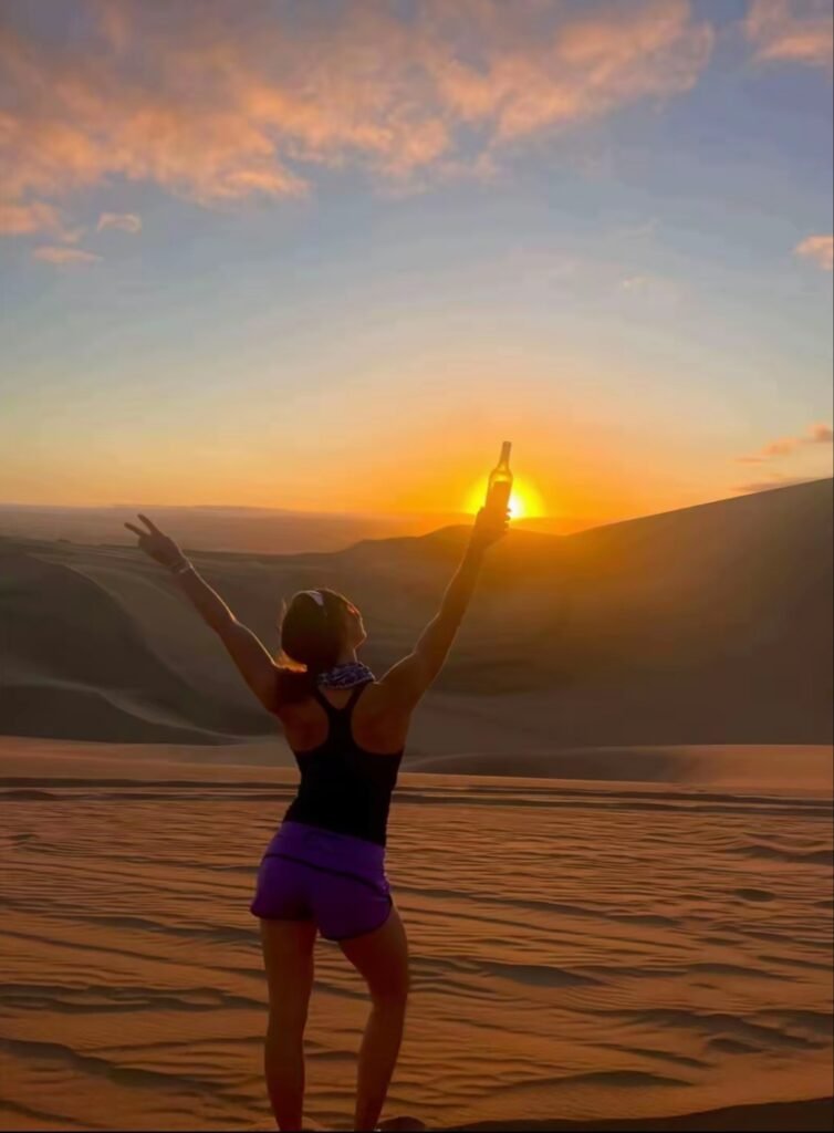 Viajera disfrutando del atardecer en las dunas de Perú